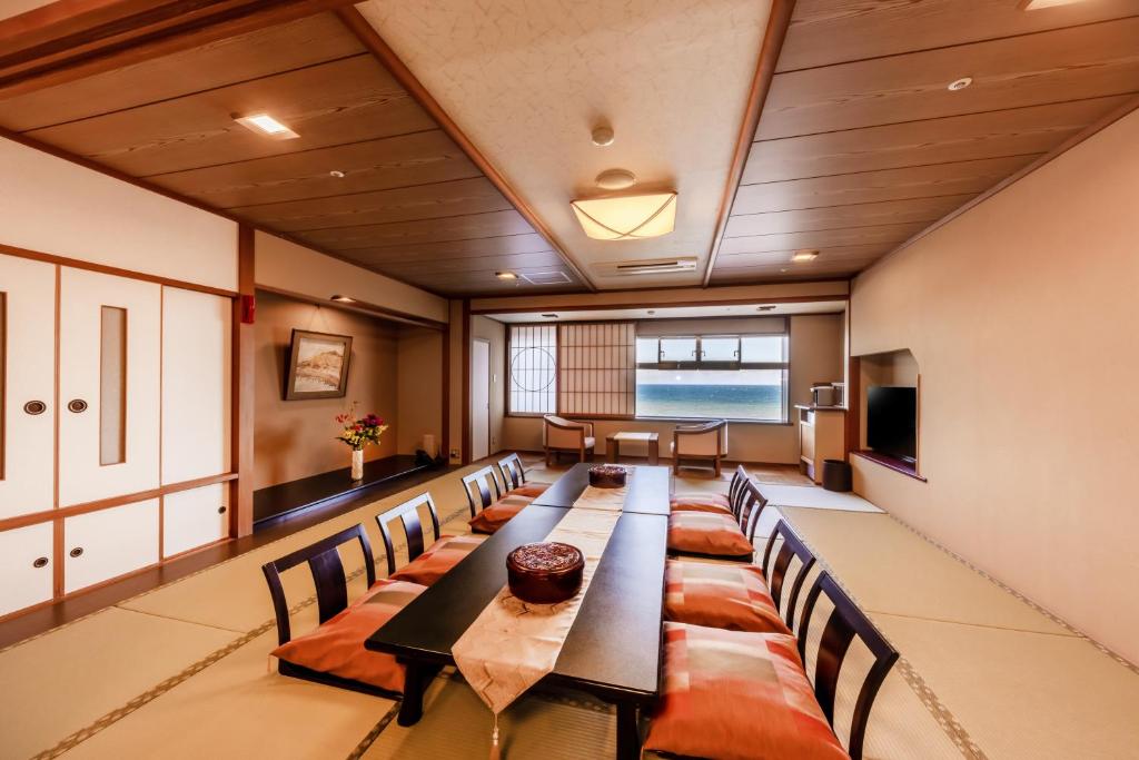 une grande salle de conférence avec une longue table et des chaises dans l'établissement 銚子グランドホテル, à Choshi