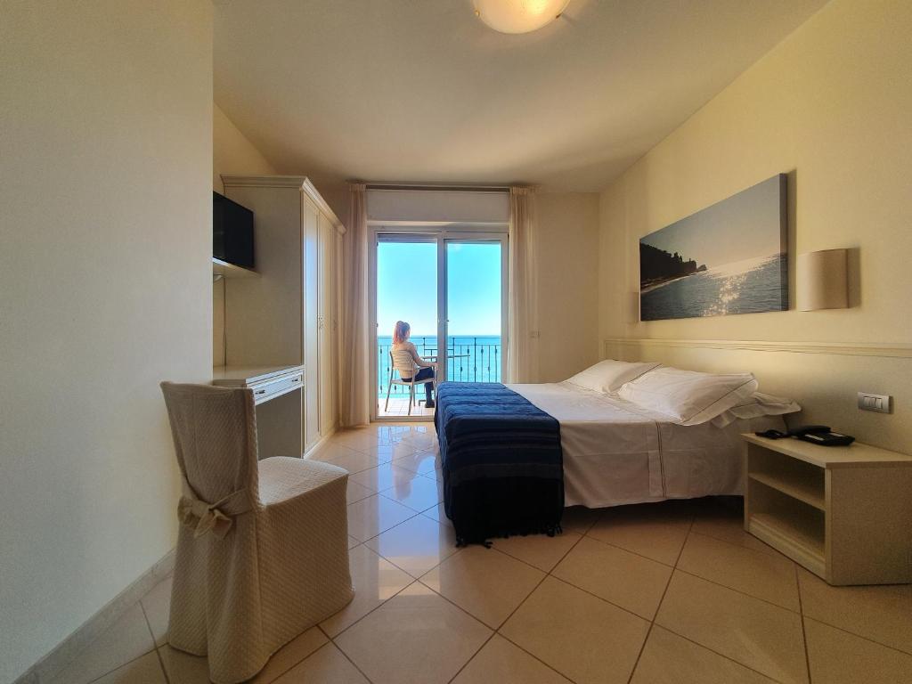 une chambre avec un lit et une vue sur l'océan dans l'établissement Lido Resort, à Finale Ligure