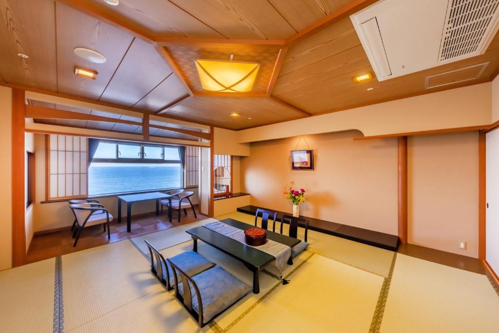 un salon avec une table et des chaises dans l'établissement 銚子グランドホテル, à Choshi