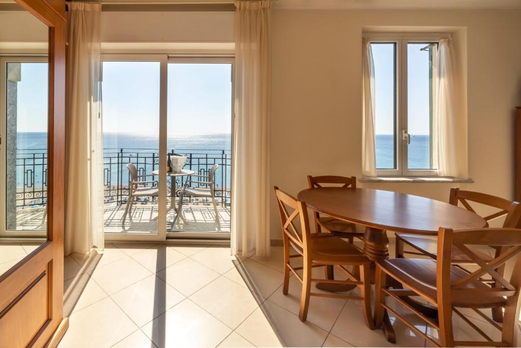 une salle à manger avec une table et des chaises et un balcon dans l'établissement Lido Resort, à Finale Ligure