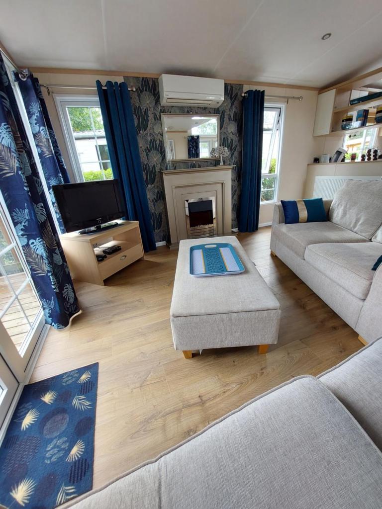un salon avec un canapé et une cheminée dans l'établissement Mobilhome - Kedidrouz du Léon - Kerlann - Pont Aven, à Pont-Aven 32 autres photos