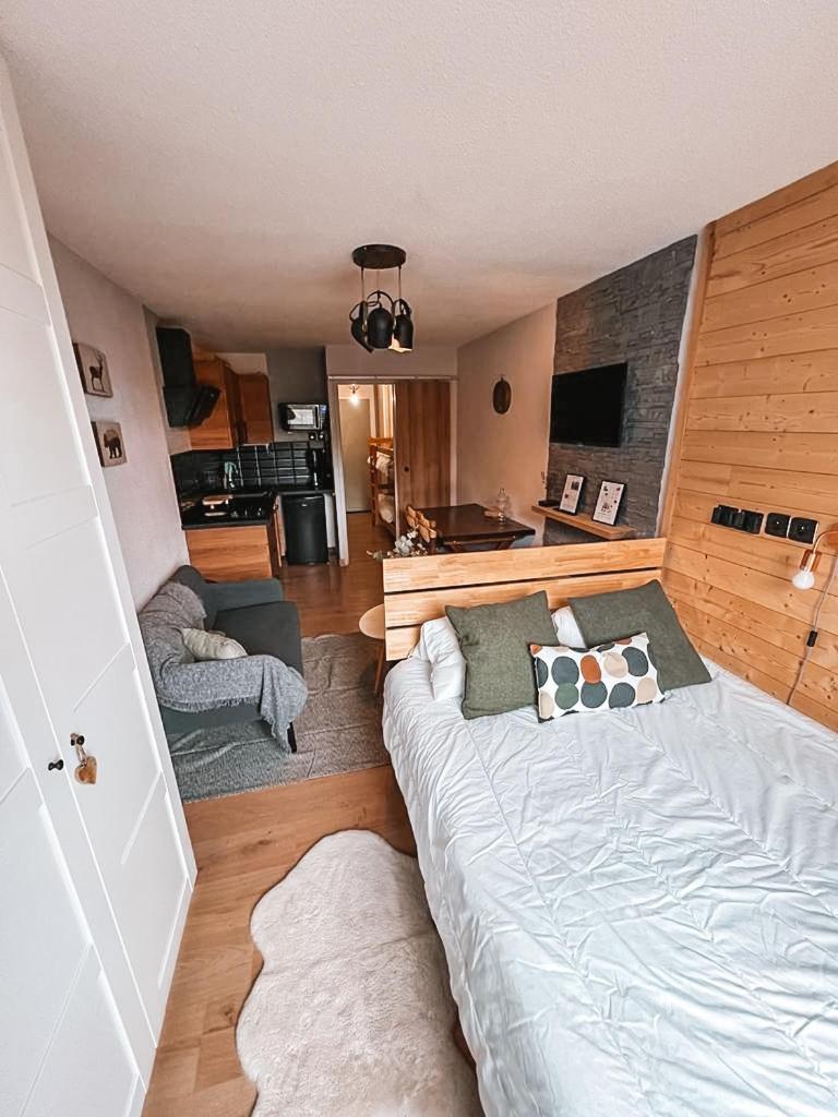 une chambre avec un grand lit et un salon dans l'établissement LA FOUX D'ALLOS Centre station, vue panoramique Quartier les étoiles 50m des remontées, à Allos