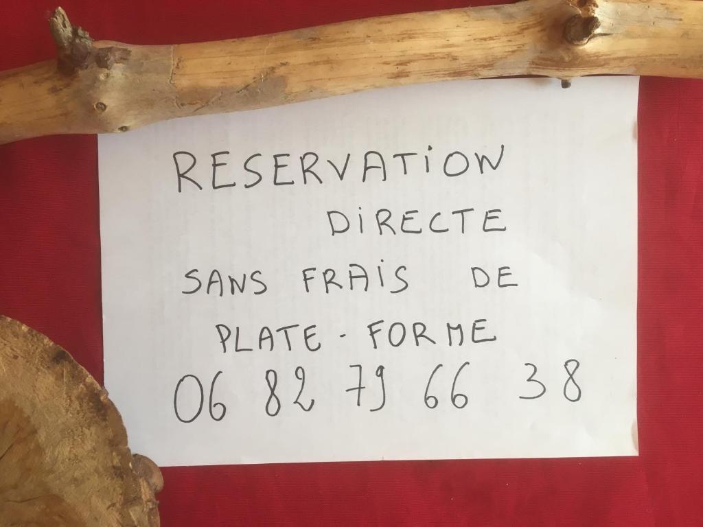 un panneau sur un bâton en bois sur un mur dans l'établissement La pause tiny, à Ploërmel