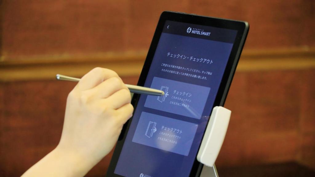 une personne tenant un stylo devant un téléphone portable dans l'établissement Yutorelo Nasushiobara, à Nasushiobara