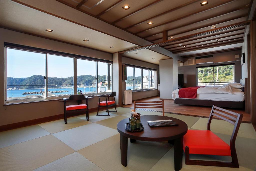une chambre avec un lit, une table et des chaises dans l'établissement Uminoniwa, à Kamogawa