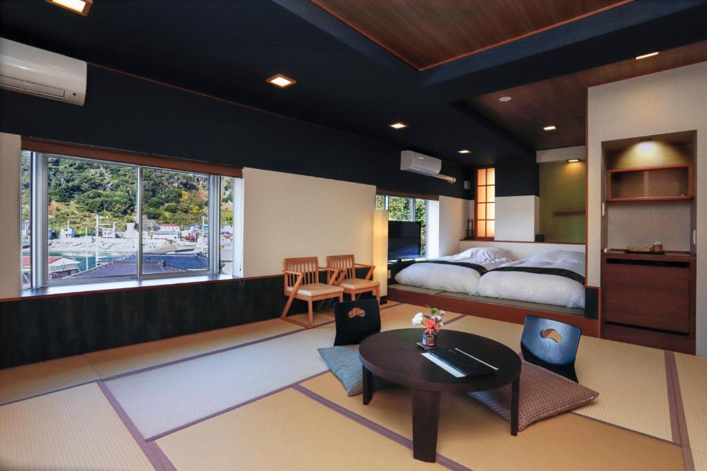 une chambre avec un lit, une table et des chaises dans l'établissement Uminoniwa, à Kamogawa