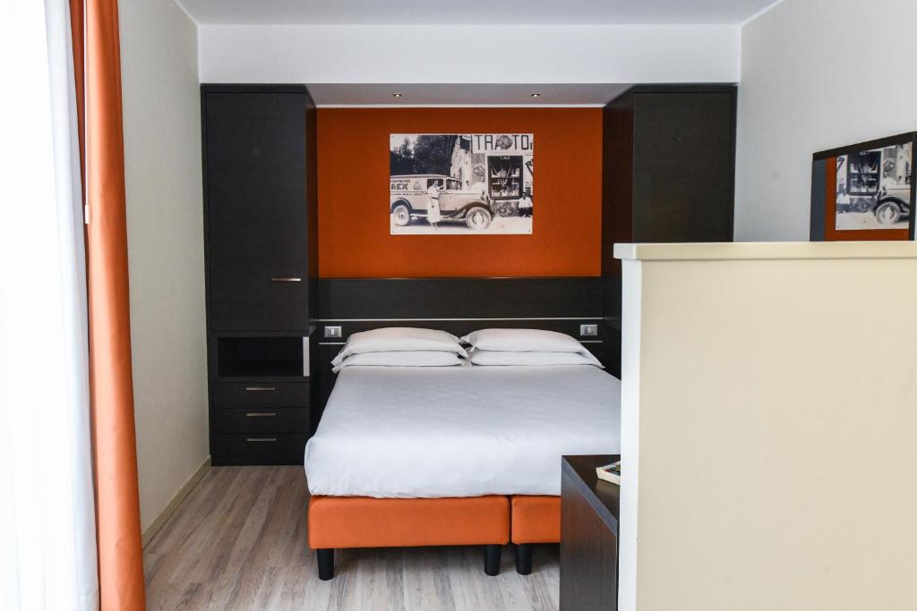une chambre avec un lit doté d'une tête de lit orange et noire dans l'établissement Hotel Vienna, à Lido di Jesolo
