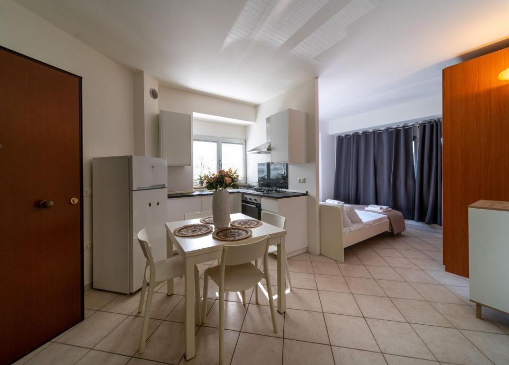une cuisine et un salon avec une table et des chaises dans l'établissement Residence Alessandra, à Cesenatico
