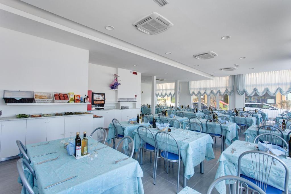 une salle à manger avec des tables et des chaises bleues dans l'établissement Hotel Platinum, à Rimini