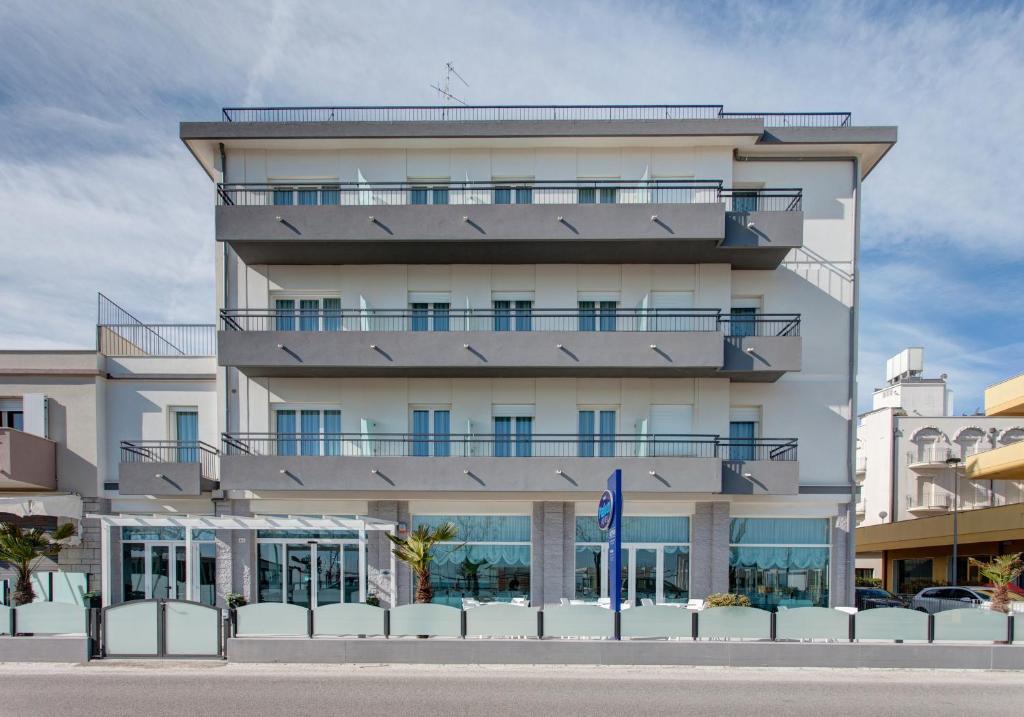 un grand immeuble blanc avec un balcon dans l'établissement Hotel Platinum, à Rimini