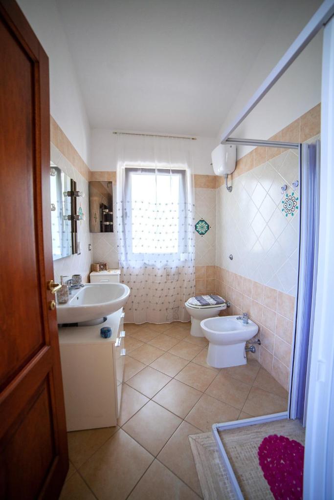 une salle de bain avec un lavabo, des toilettes et une douche dans l'établissement Villa Ottavio - SHARDAN-APARTMENTS, à Iglesias
