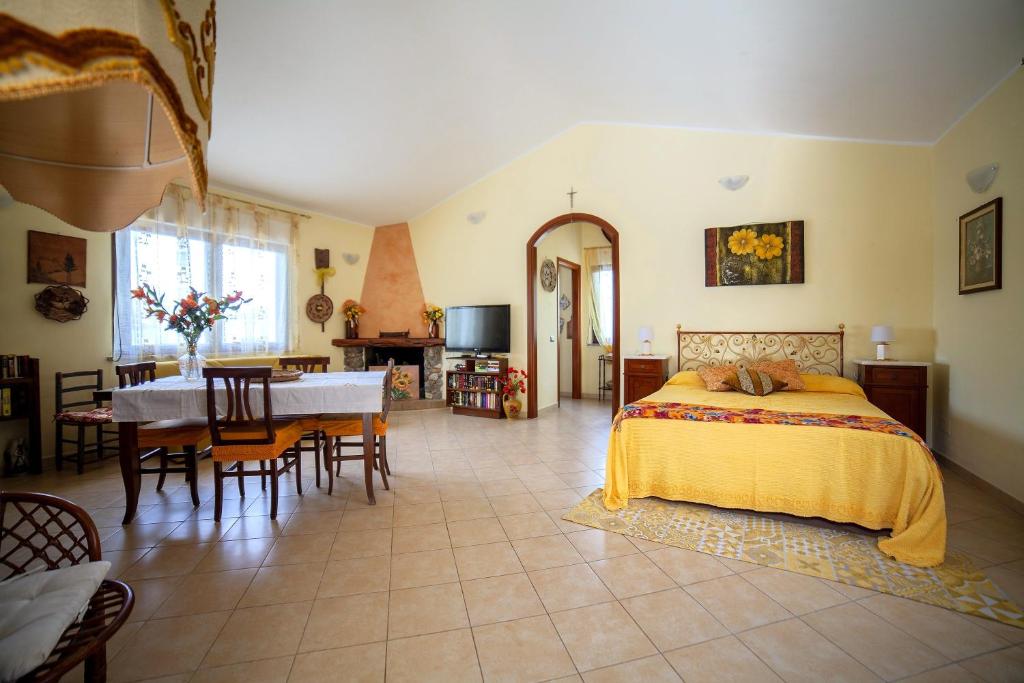 une chambre avec un lit et une table et une salle à manger dans l'établissement Villa Ottavio - SHARDAN-APARTMENTS, à Iglesias