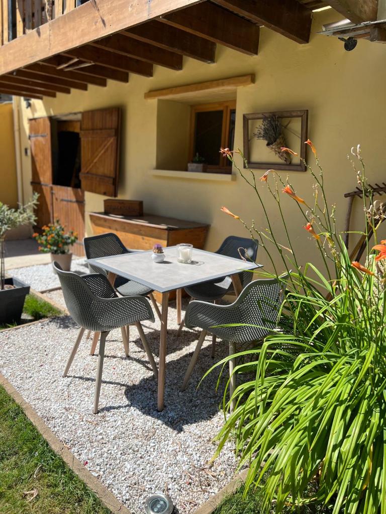 une table de pique-nique et des chaises dans un jardin dans l'établissement Gite Au Grenier Cosy, à Lor
