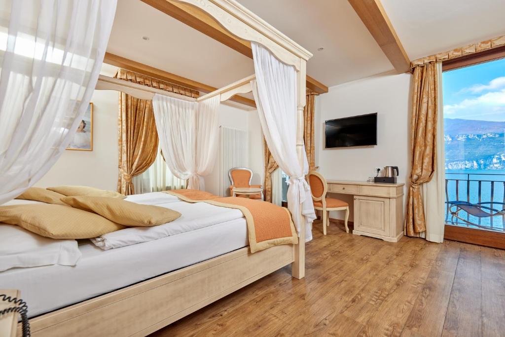 une chambre avec un lit, un bureau et une fenêtre dans l'établissement Lake Front Hotel Brenzone, à Brenzone 132 autres photos