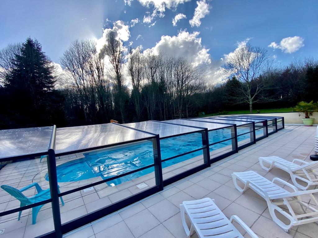 - une piscine avec 2 chaises longues et 2 chaises dans l'établissement Cabane insolite avec escape game, à Saint-Évarzec