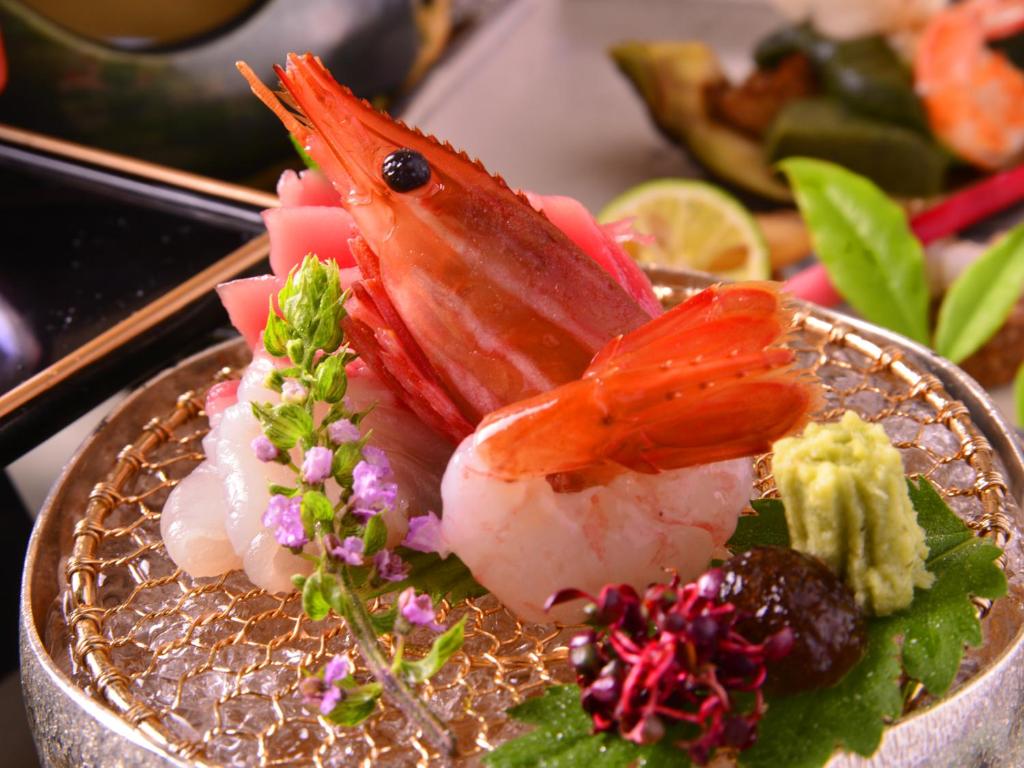 une assiette de nourriture avec des crevettes et des légumes sur elle dans l'établissement Furuya Ryokan, à Atami