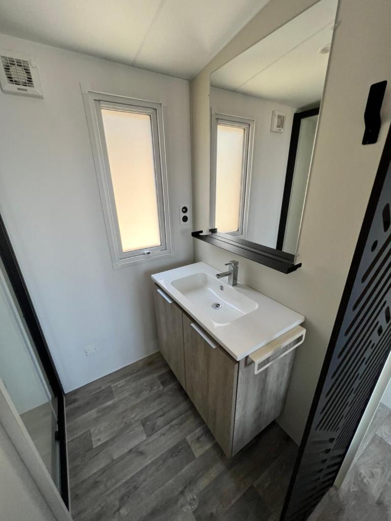 une salle de bain avec un lavabo et un miroir dans l'établissement Mobile Evasion okpl BEAUVOIR, à Saint-Raphaël 32 autres photos