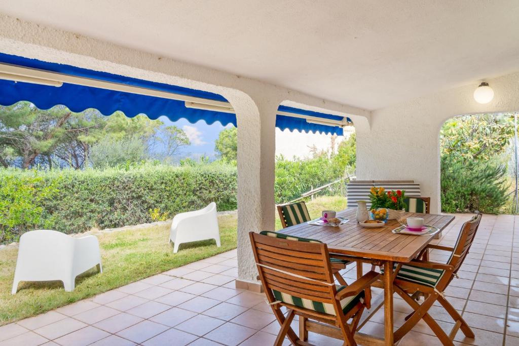 une salle à manger avec une table et des chaises sur un patio dans l'établissement Villa Viola, à Torre delle Stelle