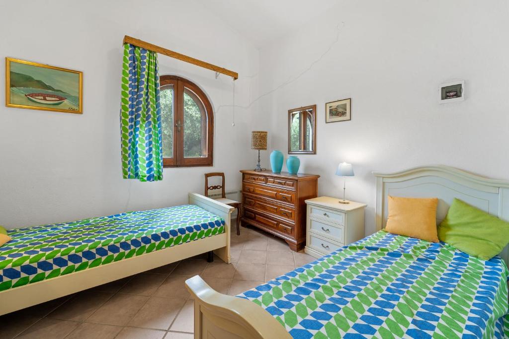 une chambre avec deux lits et une commode dans l'établissement Villa Viola, à Torre delle Stelle