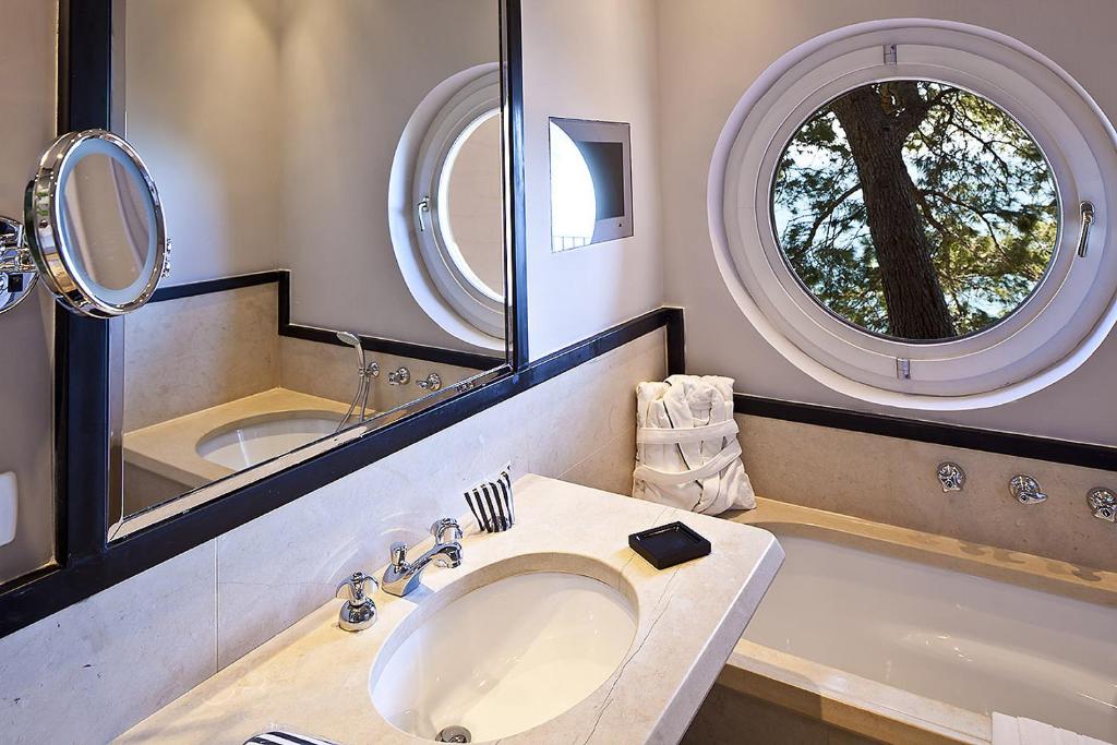 une salle de bain avec un lavabo et deux miroirs dans l'établissement Regina Isabella-Resort Spa Restaurant, à Ischia