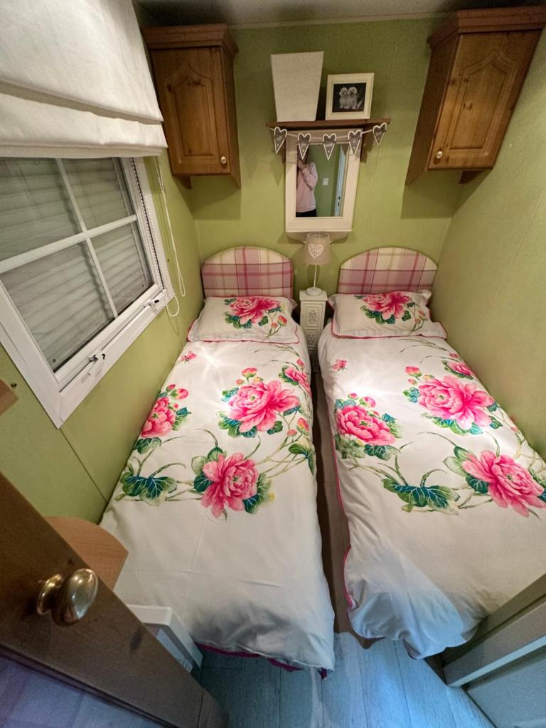 deux lits dans une petite pièce avec une fenêtre dans l'établissement Mobile Home, Camping Le Dattier, Fréjus, South of France, à Fréjus 29 autres photos