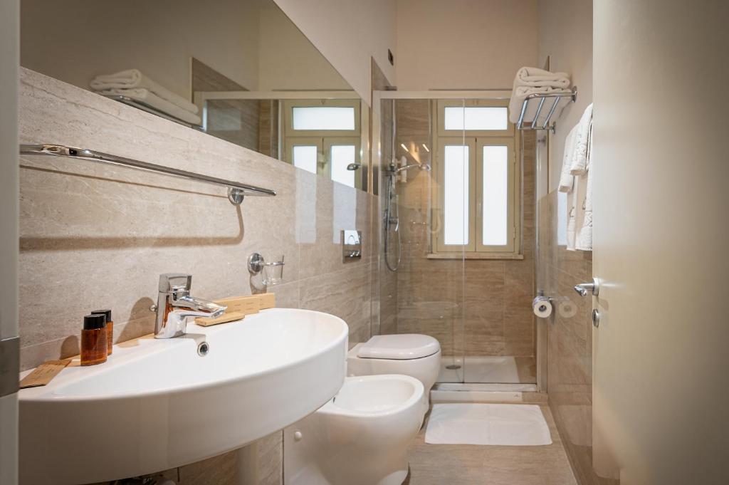 une salle de bain avec un lavabo et des toilettes dans l'établissement Hotel Sabbie d'Oro, à Giardini Naxos