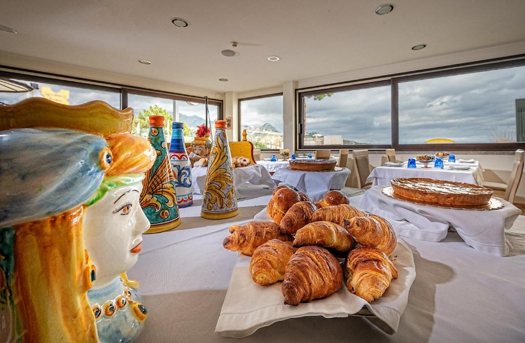 - une table avec des croissants et d'autres viennoiseries dans l'établissement Hotel Sabbie d'Oro, à Giardini Naxos