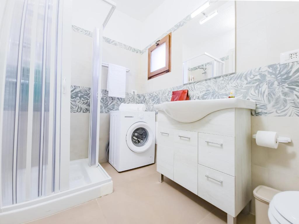 une salle de bain avec un lavabo et une machine à laver dans l'établissement Villetta Oasi nelle Rocce con Piscina Privata, à Acquarica del Capo