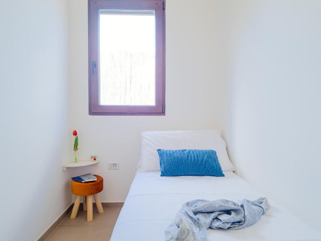 une chambre avec un lit blanc et une fenêtre dans l'établissement Villetta Oasi nelle Rocce con Piscina Privata, à Acquarica del Capo