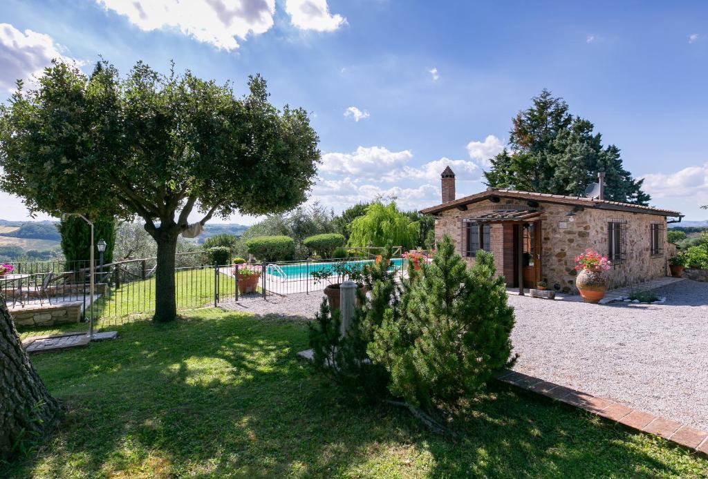 une maison en pierre avec un jardin et une piscine dans l'établissement Villetta Armaiolo, à Rapolano Terme