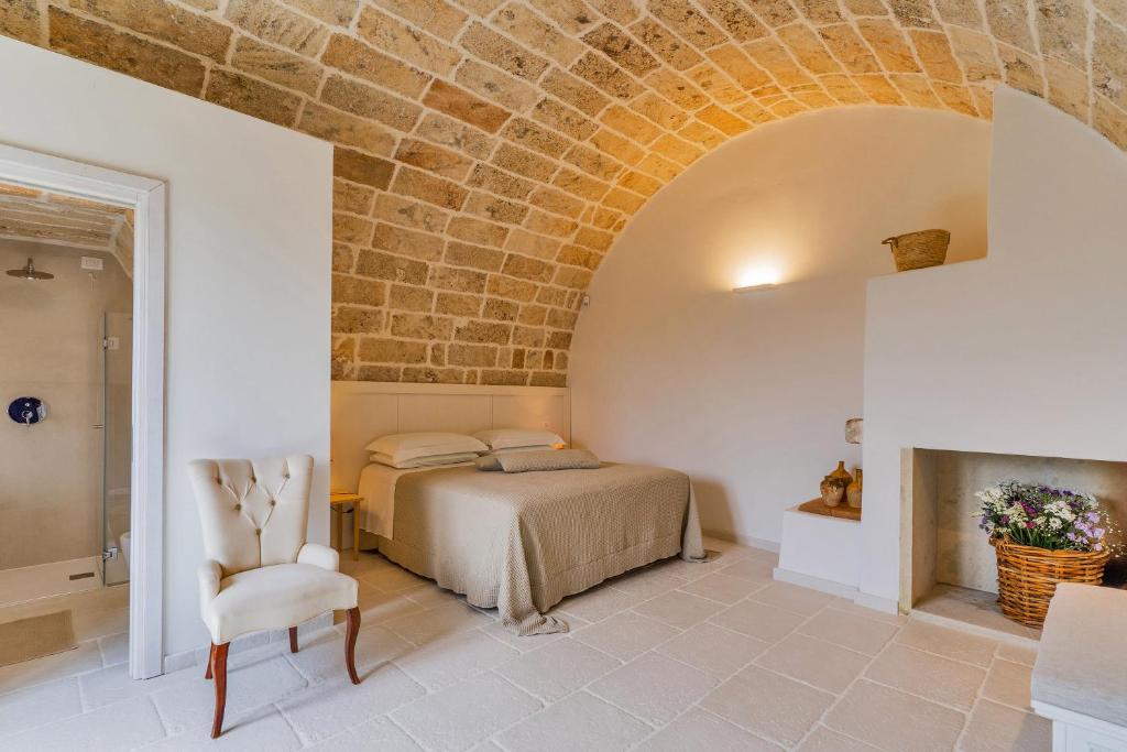 une chambre avec un lit et un mur de briques dans l'établissement Masseria Macchiaforte, à Gallipoli