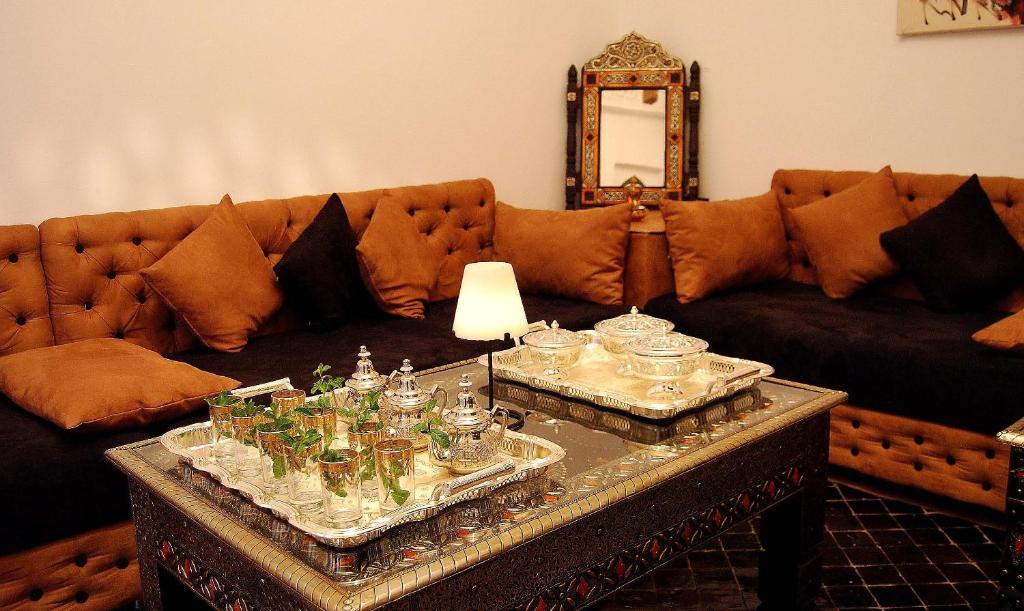 - un salon avec un canapé et une table avec des verres dans l'établissement Hotel Riad Todos, à Marrakech