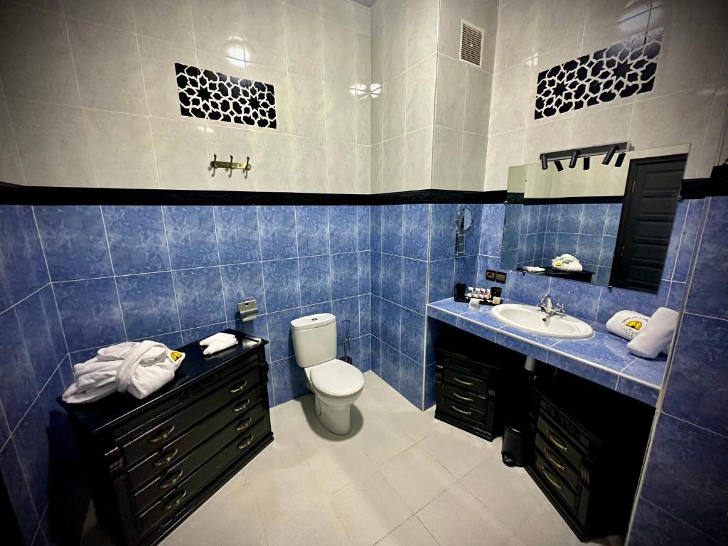 La salle de bains est pourvue de carrelage bleu, de toilettes et d'un lavabo. dans l'établissement Riad Soir De Marrakech, à Marrakech