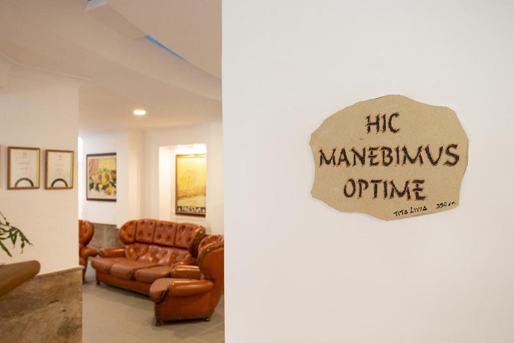 un salon avec un canapé et une pancarte sur la porte dans l'établissement Hotel Poseidonia Mare, à Paestum 21 autres photos