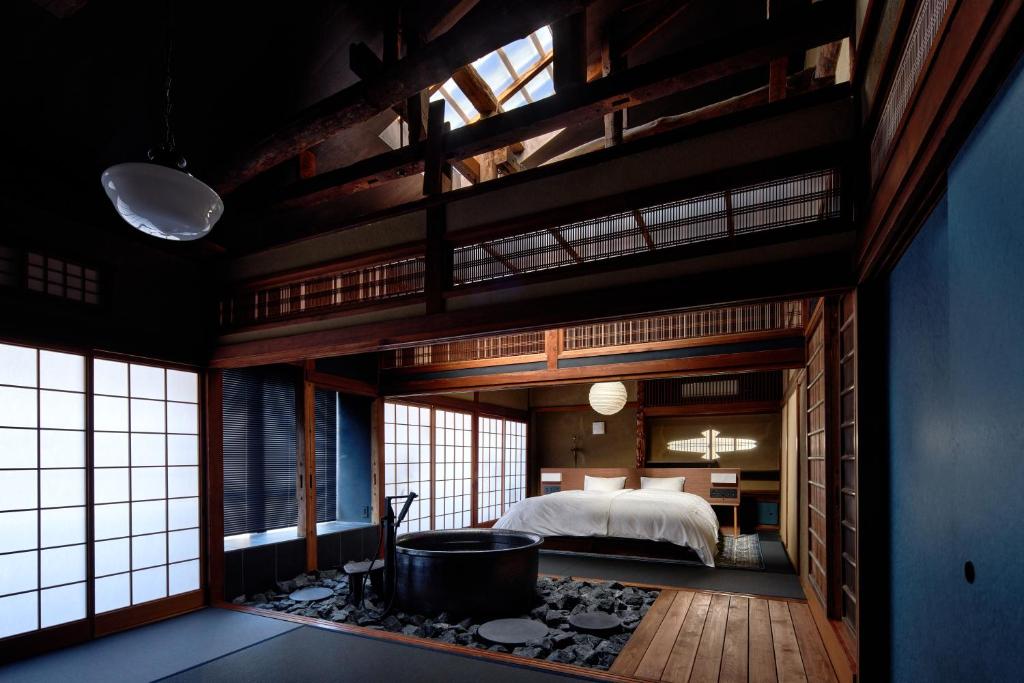 une chambre avec un lit et une baignoire dans l'établissement 城崎温泉 旅館 つばき乃 - Kinosaki Onsen Ryokan Tsubakino, à Toyooka