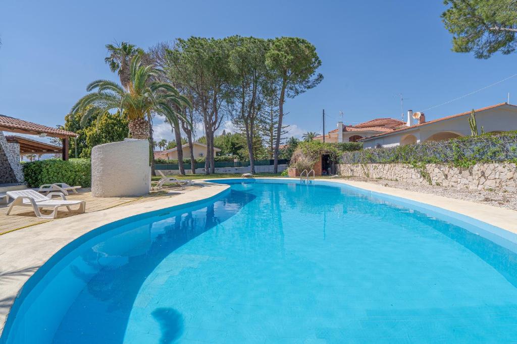 une grande piscine bleue dans une cour dans l'établissement Bes Beach - Villa con piscina, à Fontane Bianche