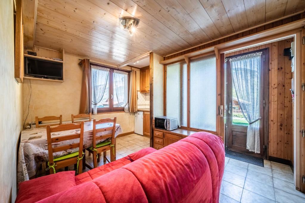 un salon avec un canapé rouge et une table dans l'établissement Studio Chénives - Morzine, à Morzine
