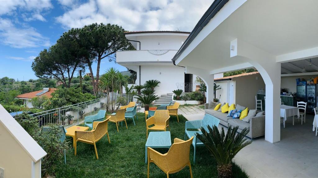 un patio avec des chaises et un canapé sur l'herbe dans l'établissement HOTEL MERCURIO SUL MARE - Fish restaurant and private beach, à Capo Vaticano 75 autres photos