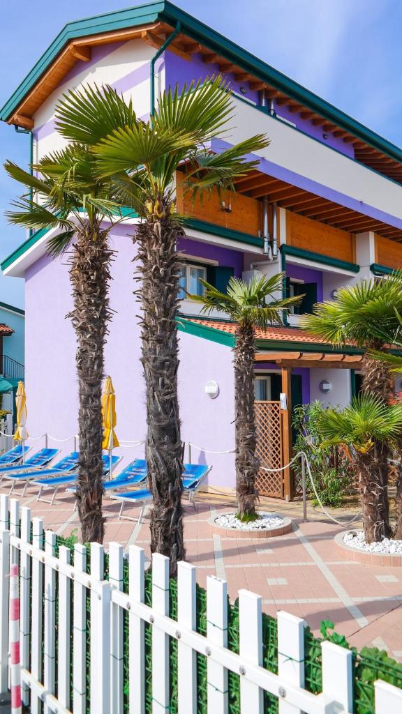 une maison avec des palmiers devant dans l'établissement Villaggio Margherita, à Caorle
