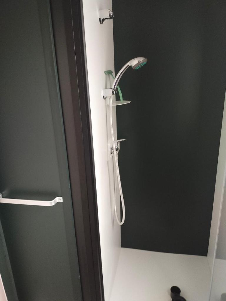 une douche avec pommeau de douche dans une salle de bain dans l'établissement MOBIL HOME LE BIENVENUE 3 CH VALRAS PLAGE, à Valras-Plage
