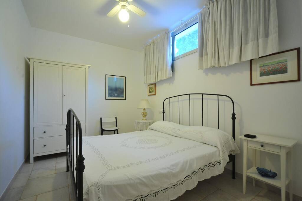 une chambre blanche avec un lit et une fenêtre dans l'établissement CASA NEL VERDE CON GIARDINO E PISCINA PRIVATA, à Polignano a Mare