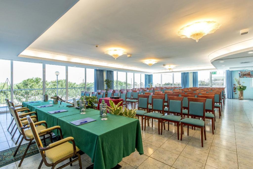 une salle de conférence avec des tables, des chaises et des fenêtres dans l'établissement Hotel Ambassador, à Tortoreto Lido 66 autres photos