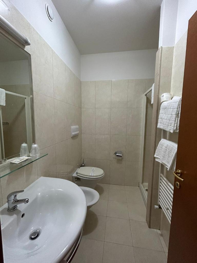 une salle de bain avec un lavabo et des toilettes dans l'établissement Bikini Hotel, à Vieste