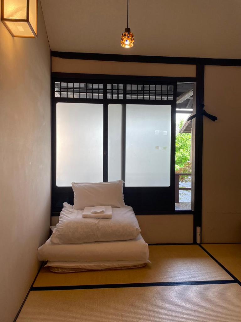 Cette chambre dispose d'un lit en face d'une fenêtre. dans l'établissement Roman Kan, à Kyoto
