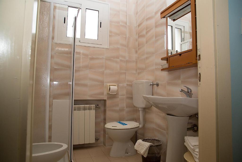 une petite salle de bain avec toilettes et lavabo dans l'établissement Hotel Umberto, à Rosolina Mare 51 autres photos