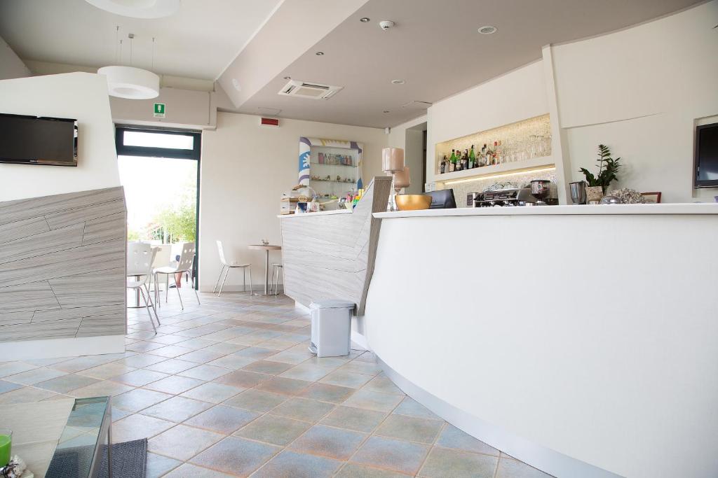 - un bar dans une salle avec un comptoir et des chaises dans l'établissement Hotel Umberto, à Rosolina Mare