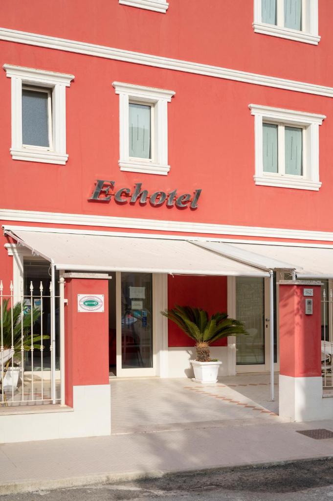 un bâtiment rouge avec un panneau Betfred dessus dans l'établissement Echotel, à Porto Recanati