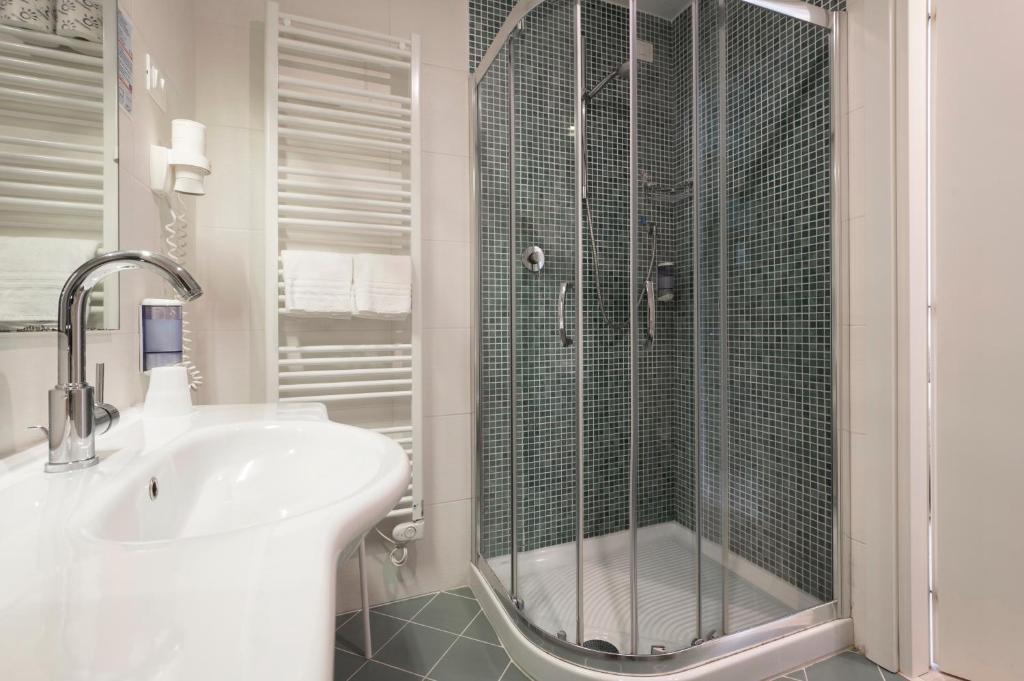 une salle de bain blanche avec une douche et un lavabo dans l'établissement Echotel, à Porto Recanati