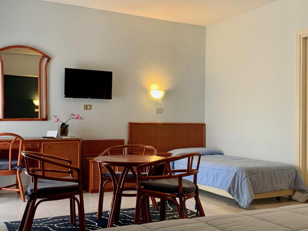 une chambre avec un lit, une table et des chaises dans l'établissement River Park Hotel, à Ameglia
