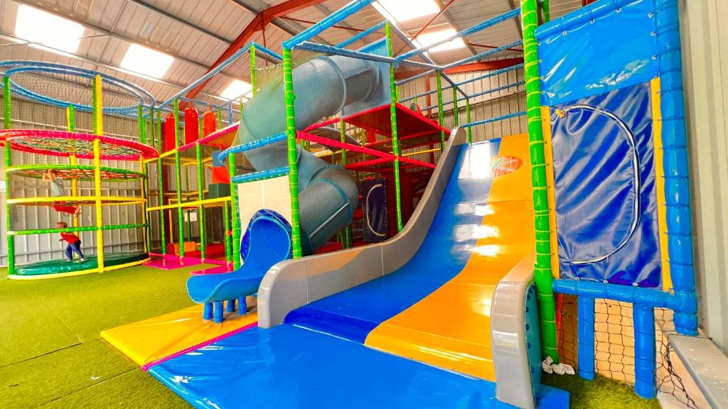 - une aire de jeux avec toboggan dans une pièce dans l'établissement Camping Country Park Touquin - Site Officiel - Next to Disneyland Paris, à Touquin